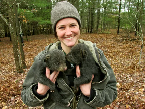 Jennifer Smith holding two bear cubs.