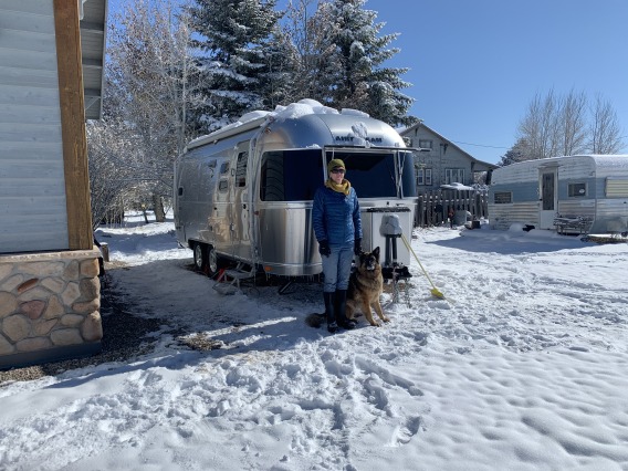 Tamara Wall standing next to an airstream trailer with her dog.