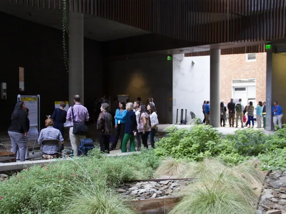 People gathering around research posters in the ENR2 courtyard.