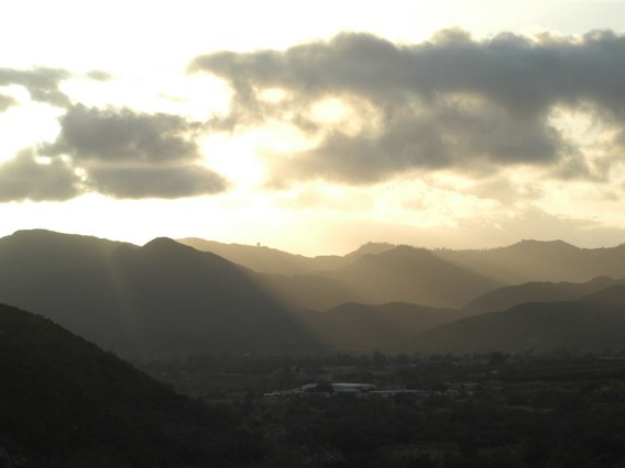 The sunset through a cloudy sky over mountains in the Pala Indian Reservation.