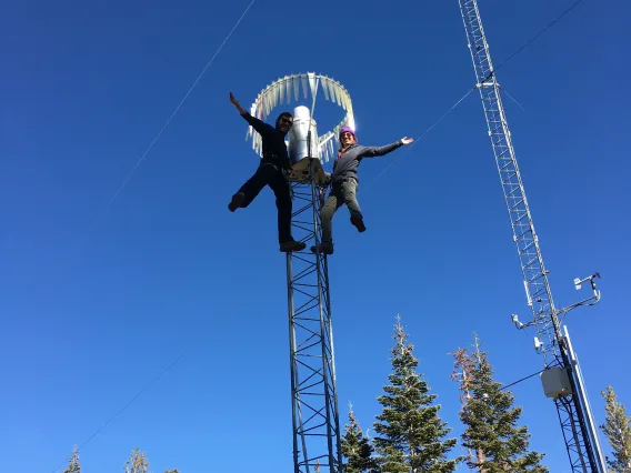 Josh Sturtevant and another researcher on top of a tower holding research equipment