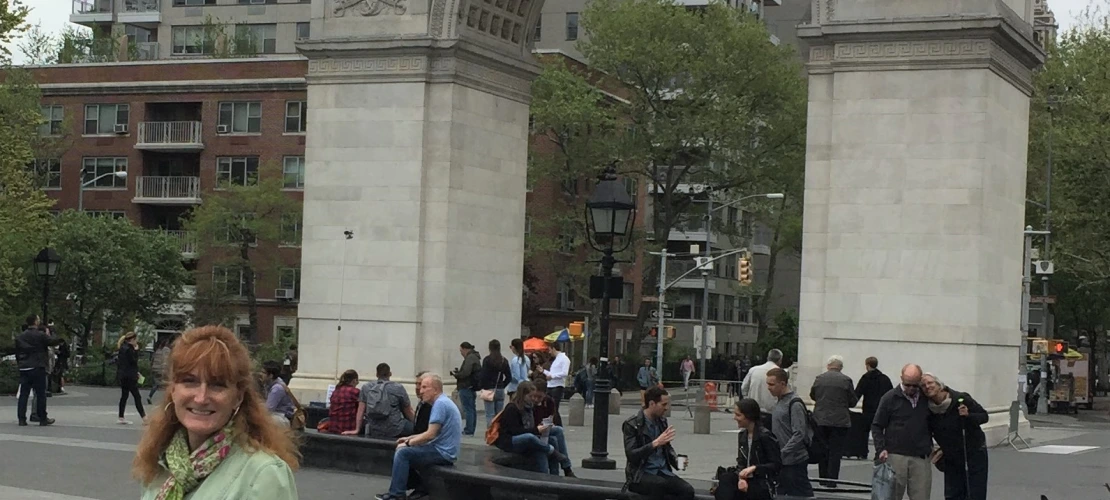 Corrina pictured in front of archway in New York City 
