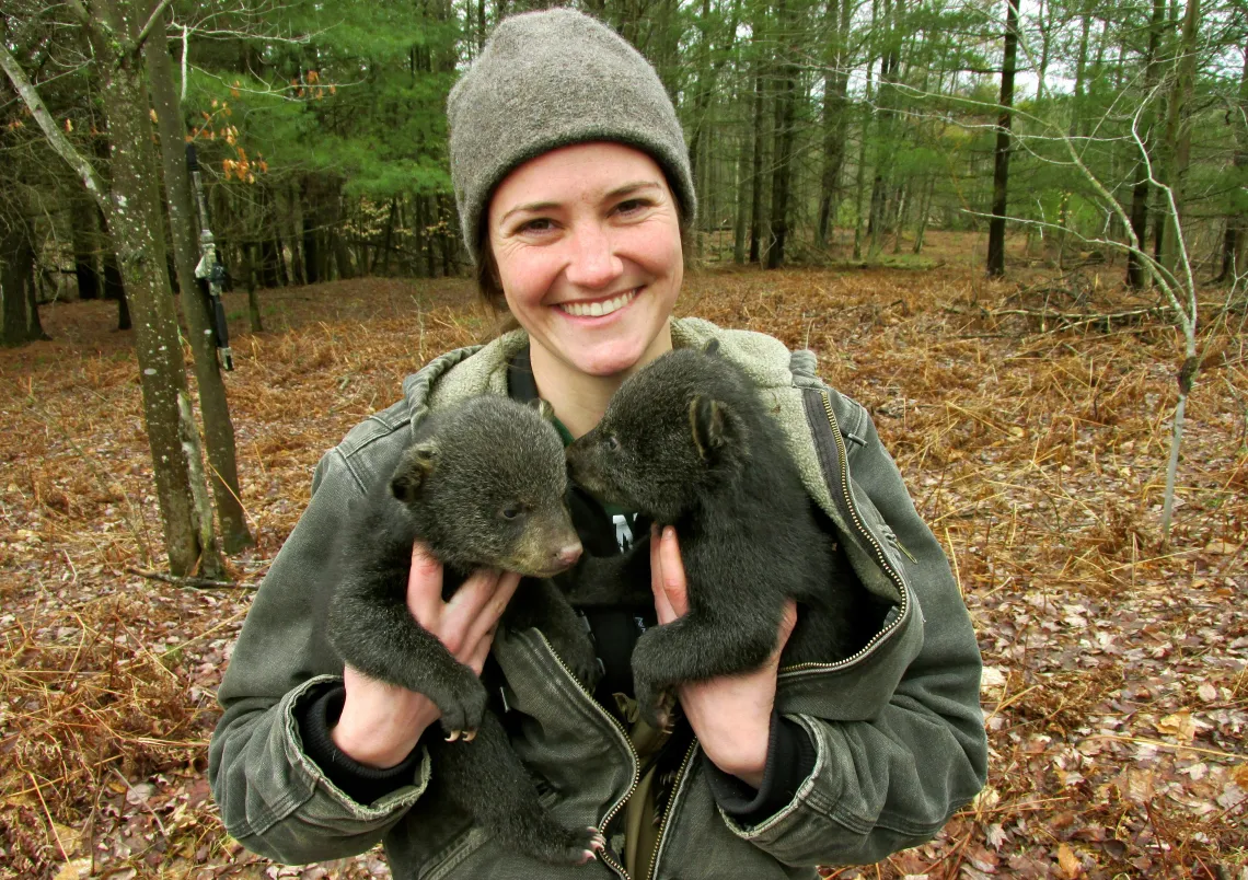 Jennifer Smith holding two bear cubs.