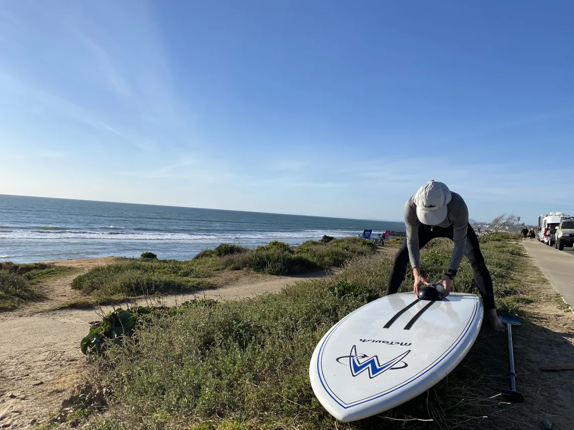 Ben Davis on the beach readying a board