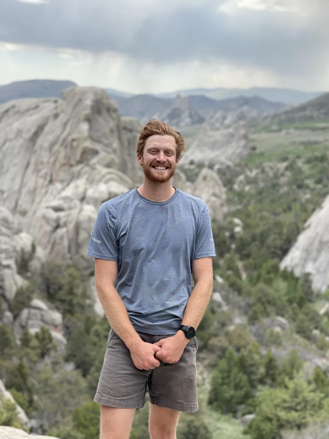 Jacob Stuivenvolt Allen standing for a photo in front of mountains at a high altitude.