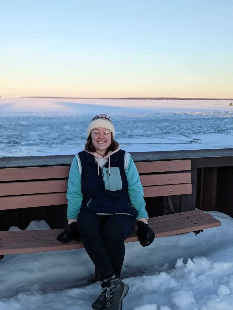 Erin sitting on a bench in front of the snow