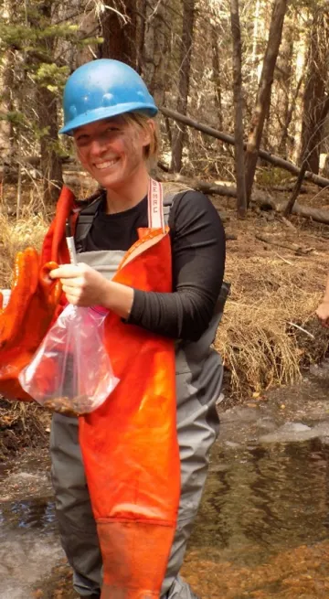 Anna in orange work attire and blue hard hat